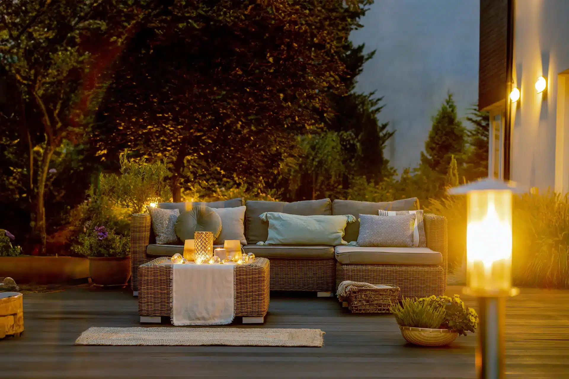 An outdoor living space with seating and lighting at dusk.